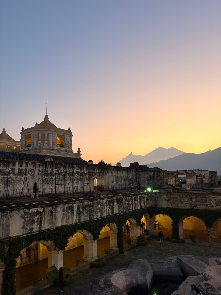 Volcan Fuego (background left) and Acatenango (background right) dominate the landscape behind the famous Iglesia de la Merced